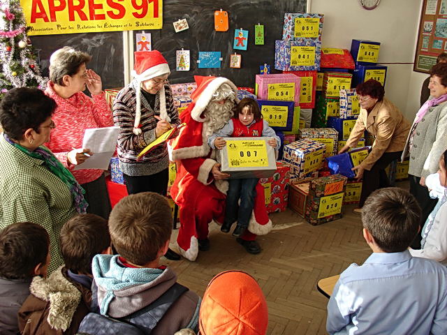 A l'cole Eliade, Daniel, Timea, Adrian et Evelin reoivent votre colis des mains du Pre Nol