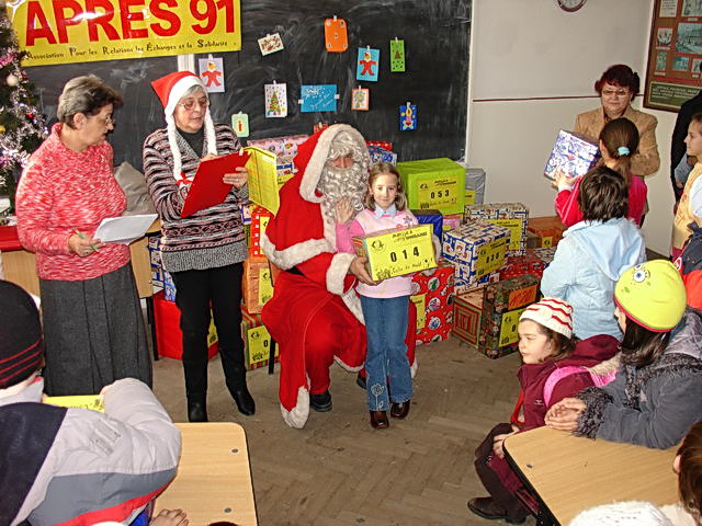 A l'cole Eliade, Daniel, Timea, Adrian et Evelin reoivent votre colis des mains du Pre Nol